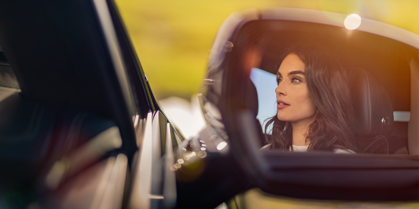 Bach Premium Cars GmbH | Bentley Mannheim profile of dark haired woman's face in mirror of Bentley car in sunlight