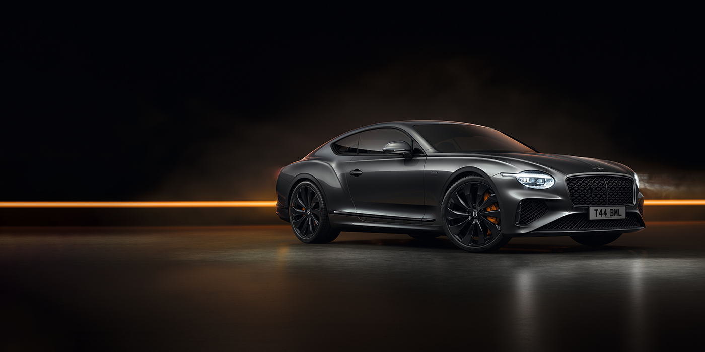 Bach Premium Cars GmbH | Bentley Mannheim Bentley Continental GT Black Edition coupe front three quarter in Anthracite black paint against a dark grey and copper background