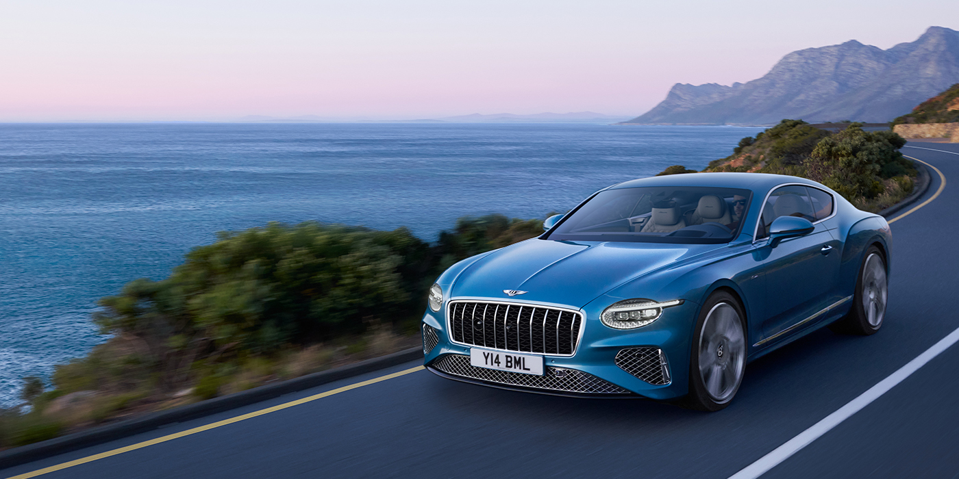 Bach Premium Cars GmbH | Bentley Mannheim New Bentley Continental GT Azure coupe in Light Windsor blue paint with 22 inch Azure wheels and chrome grill, driving dynamically by the sea