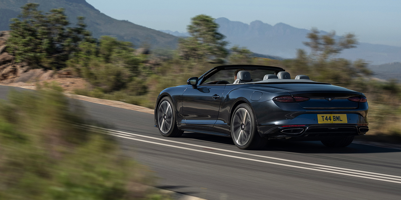 Bach Premium Cars GmbH | Bentley Mannheim Bentley Continental GTC S convertible in Thunder blue paint rear 3/4 driving on mountain road
