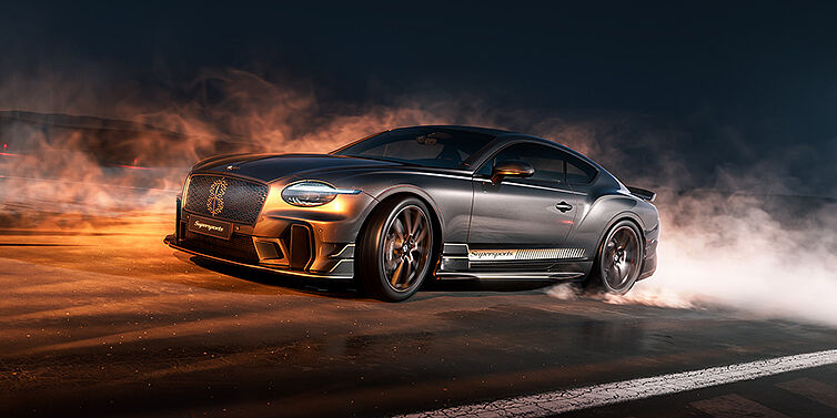 Bach Premium Cars GmbH | Bentley Mannheim Bentley Supersports front three quarter in "Nightfall" Design theme with Anthracite paint, Camel accents and Camel and Beluga black striping standing on mist covered concrete