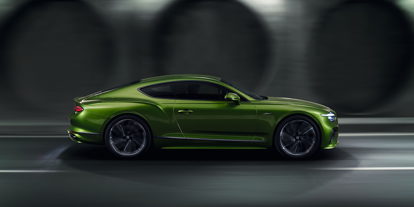 Bach Premium Cars GmbH | Bentley Mannheim Bentley Continental GT coupe in Tourmaline Green paint driving in profile on a dark road