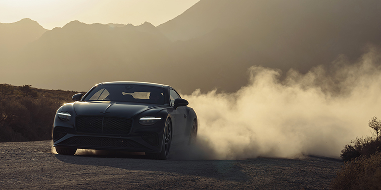 Bach Premium Cars GmbH | Bentley Mannheim Bentley Continental GT Coup&eacute; in Thunder Lackierung vorne 3/4 bei Sonnenuntergang mit Staubwolke